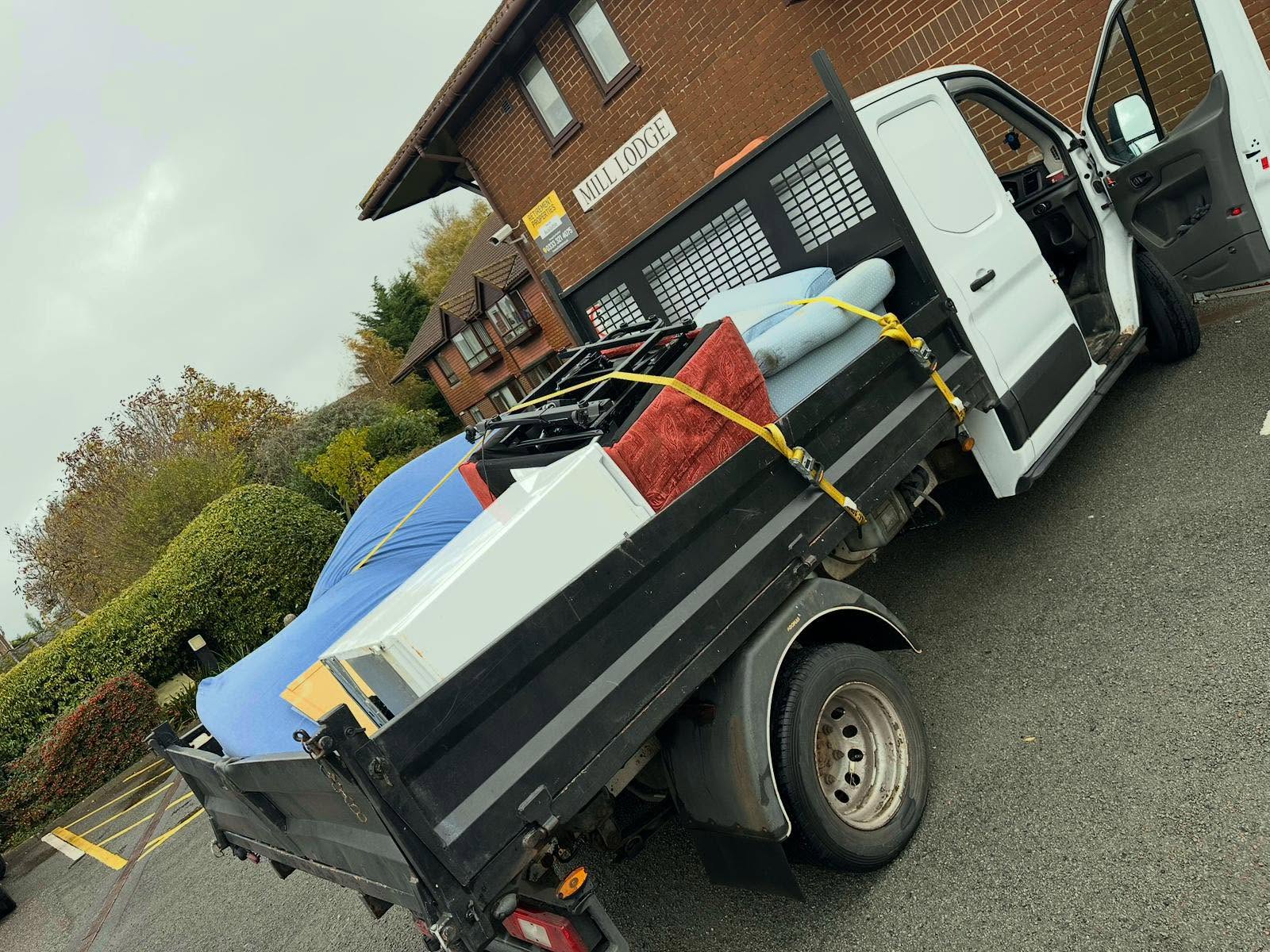 A fully loaded C1 Waste Removal truck outside a property, ready for tip